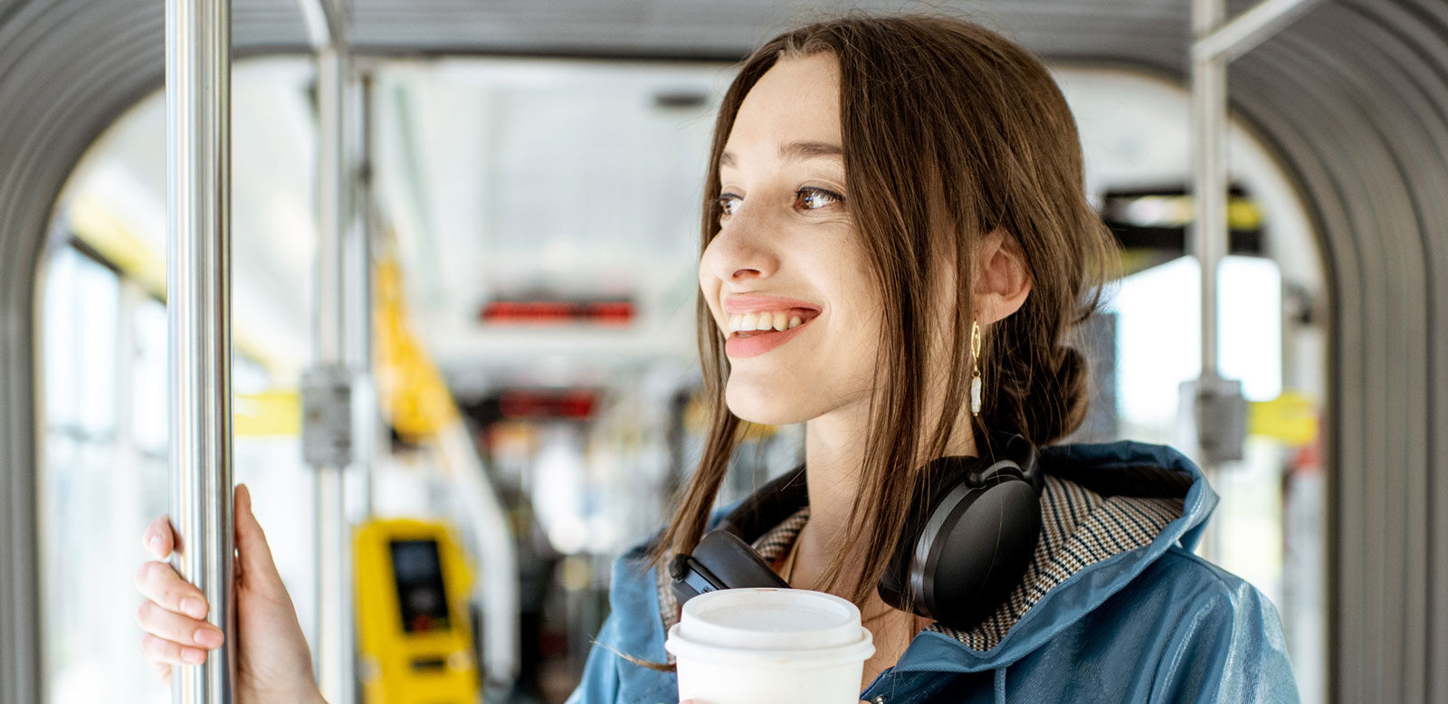 Woman travelling on a bus with a coffee